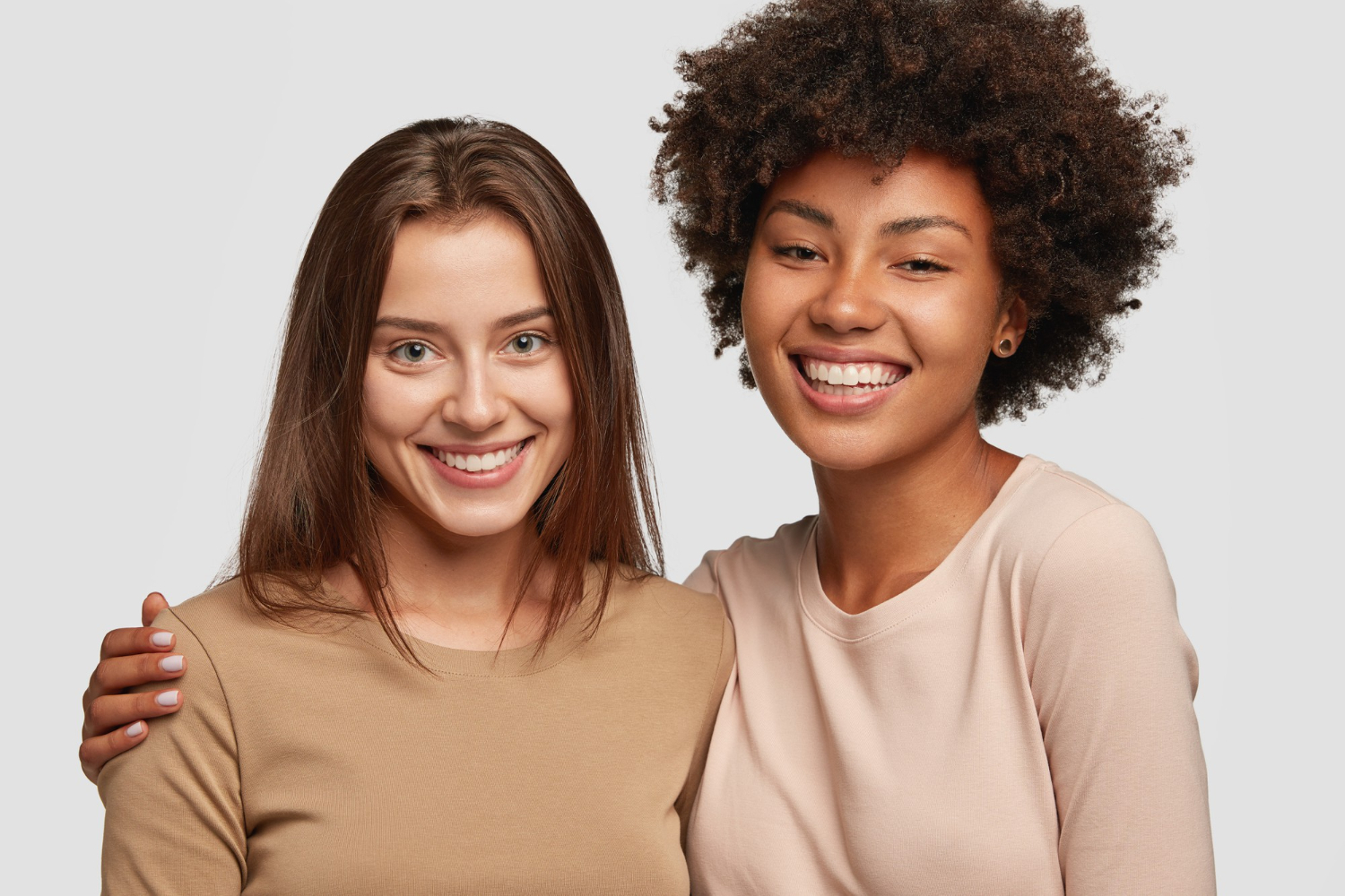 Deux étudiantes souriantes, bras autour des épaules, symbole du lien créé entre une marraine et sa filleule sur sista